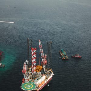 Aerial shot of an offshore oil platform with ships in a calm sea.